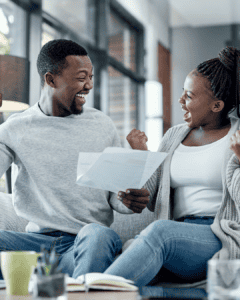 Happy couple discussing credit scores indoors, smiling confidently.